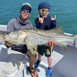 fly fishing charters on Anna Maria Man and son holding a snook