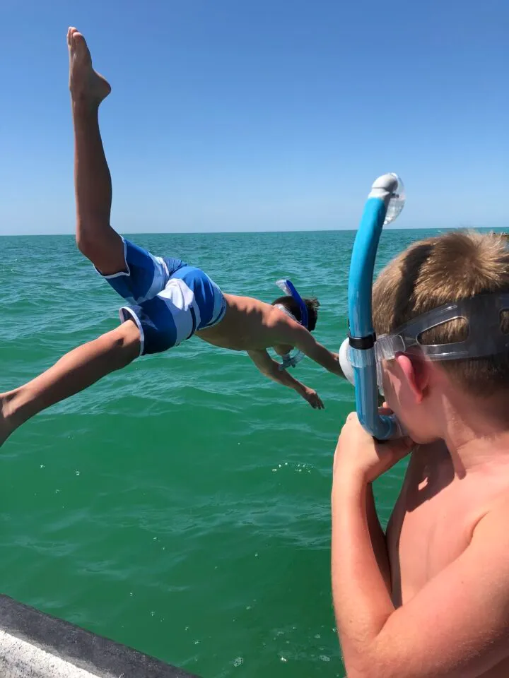 snorkeling adventures on ami Kids jumping in the gulf with snorkel gear on
