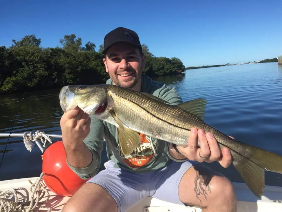 what's biting this spring Man with Snook fish