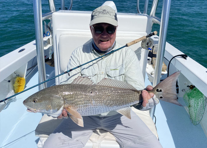 corporate fishing charters Fisherman holding up a red fish 3