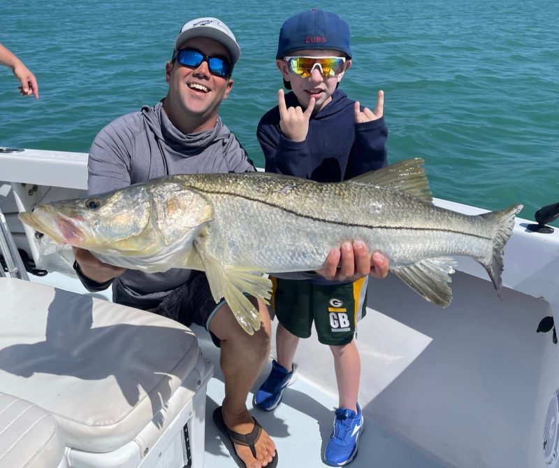 snook inshore charters fly fishing charters on Anna Maria Man and son holding a snook