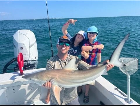 Shark fishing family holding a shark with Anna Maria Charters
